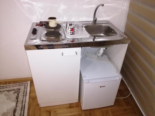 a small kitchen with a sink and a small refrigerator at ORTODOKS in Brus