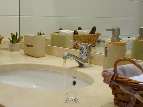 a bathroom with a sink and a mirror at LIMA COTTAGES - Casa do Cercado in Arcos de Valdevez