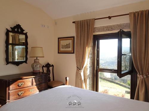 a bedroom with a bed and a window at LIMA COTTAGES - Casa do Cercado in Arcos de Valdevez