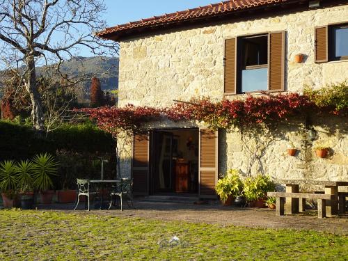 a stone house with a table in front of it at LIMA COTTAGES - Casa do Cercado in Arcos de Valdevez