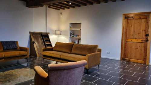 a living room with a couch and two chairs at Hoeve Spyckergoed in De Haan