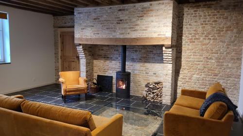 a living room with two couches and a fireplace at Hoeve Spyckergoed in De Haan