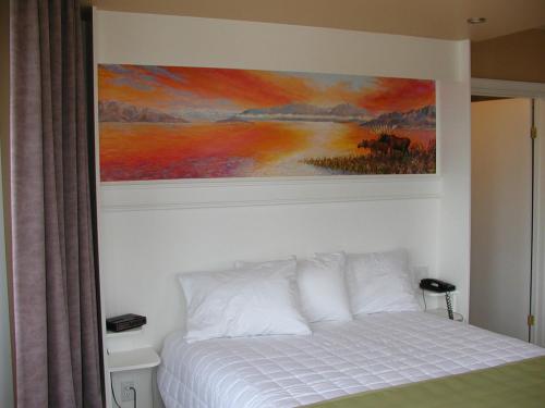 a bedroom with a painting above a bed at Almo Court Motel in Cranbrook