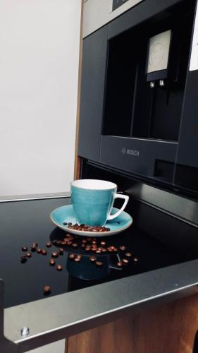 a cup on a plate next to a microwave at No 7 Apartament Spa z sauna i jacuzzi in Nowy Targ