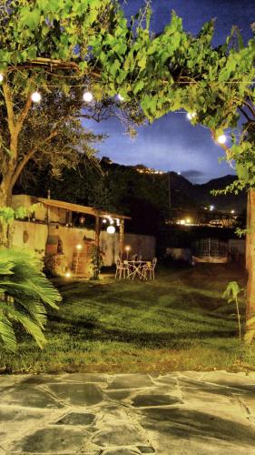 a backyard at night with a table and lights at Casa Vacanze Borgo Borghese in SantʼAlessio Siculo