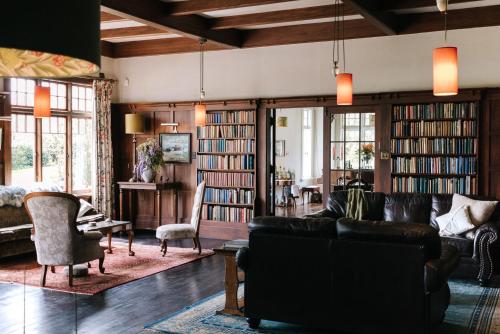 un soggiorno con divano, sedie e libri di Wallingford Homestead a Wallingford