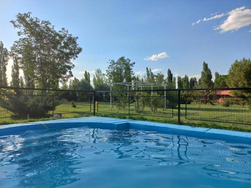 a swimming pool in a yard with a fence at Cabañas Aramaití in San Rafael
