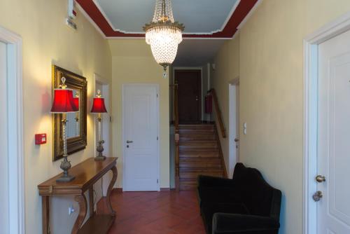 a hallway with a chandelier and a table and a chair at Archontiko Argyro in Makrinítsa