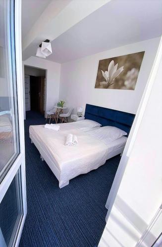a bedroom with a large white bed in a room at Apartamenty Planeta Mielno in Mielno