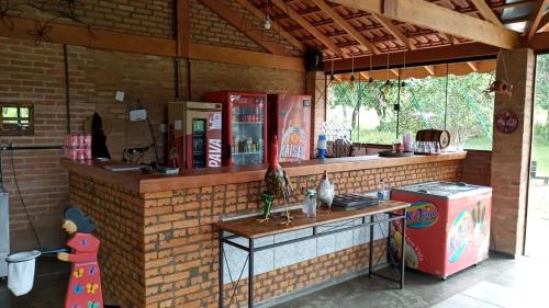 a kitchen with a counter in a brick wall at Pousada & Restaurante Chico Bento in Lambari