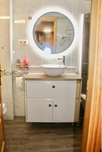 a bathroom with a white sink and a mirror at CHECK-IN CASAS Luana in Benasque