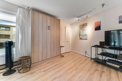 a living room with a large wooden cabinet and a tv at Snowblaze Studio in Winter Park