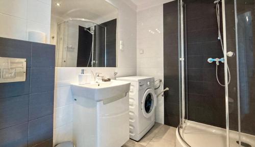 a bathroom with a washing machine and a sink at Apartament Atlantycki in Jastrzębia Góra