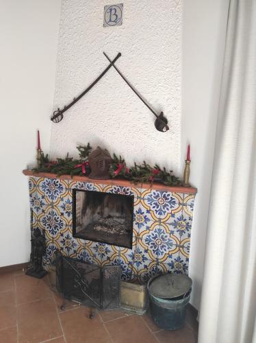 a fireplace with christmas decorations on top of it at Cottage in fattoria in Isnello
