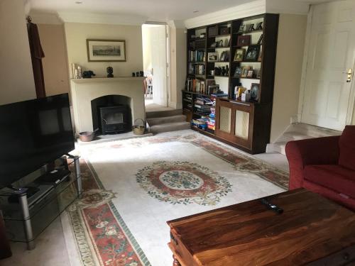 a living room with a fireplace and a tv at Stanton House Annex in Bakewell