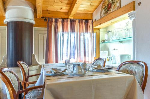 jadalnia ze stołem i krzesłami oraz oknem w obiekcie B&B Alla Loggia dell'Imperatore w mieście Levico Terme