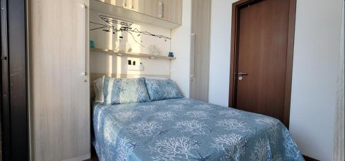 um quarto com uma cama com um edredão azul em Cozy Loft (Oceanview) em Niterói