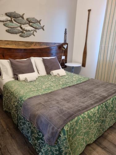 a bedroom with a large bed with a green blanket at VILLA VILLACOLLE in Procchio