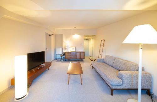 a living room with a couch and a television at Hotel Stelle Belle in Hakuba