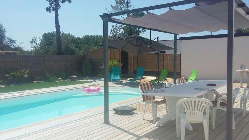 - une terrasse avec une table et un parasol à côté de la piscine dans l'établissement House with private pool, à Saint-Jean-de-Monts