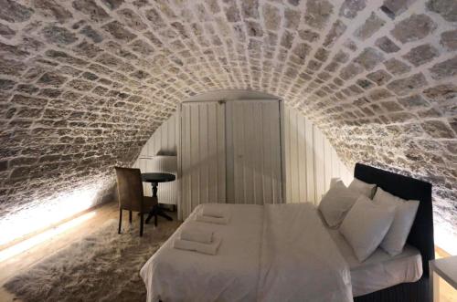 a bedroom with a bed and a brick wall at Soul boutique hotel in Monodendri