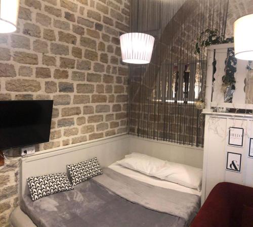 a bed in a room with a brick wall at Soul boutique hotel in Monodendri
