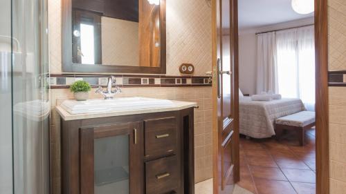 ein Badezimmer mit Waschbecken und Spiegel in der Unterkunft Caserío de Aljibillos 5 hab 8 camas 4 baños in Toledo