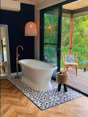 a large bathroom with a tub and a chair at Fletchers Ridge - Guest House in Montville
