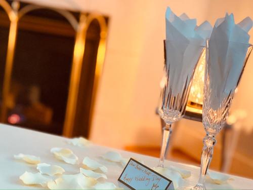 two champagne glasses on a table with flowers at Princess and the Pea Hotel in Langley