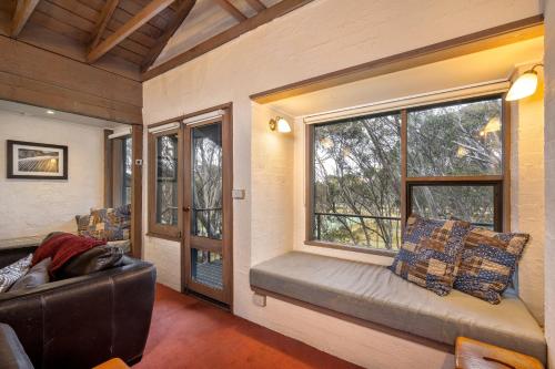 a living room with a couch and a window at Snowgums 13 in Dinner Plain