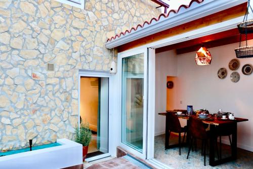 a dining room with a table and a stone wall at Constância Guest House in Constância