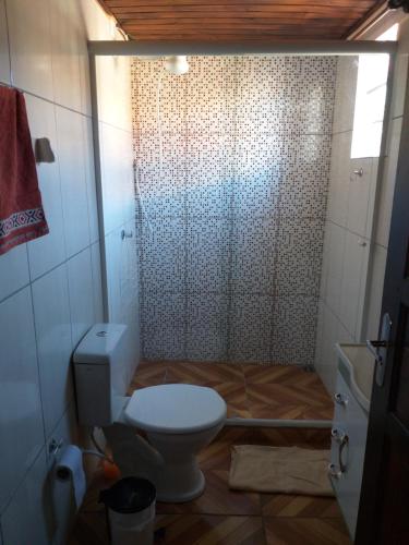 a bathroom with a toilet and a shower at Chalé Sattwa Prudentópolis/WIFI/Pet/garagem in Prudentópolis
