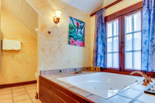 een grote badkamer met een bad en een raam bij Mahogany Hall Gold Standard Certified in San Ignacio