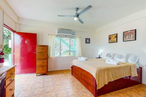a bedroom with a bed and a red wall at Willow 2 at Island Cabanas Gold Standard Certified in Caye Caulker
