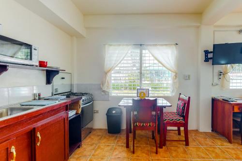 a kitchen with a table and chairs and a window at Willow 2 at Island Cabanas Gold Standard Certified in Caye Caulker