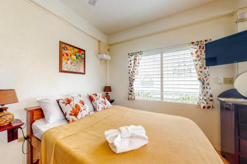 1 dormitorio con 1 cama grande con manta amarilla en Almond Tree 3 at Island Cabanas Gold Standard Certified en Caye Caulker