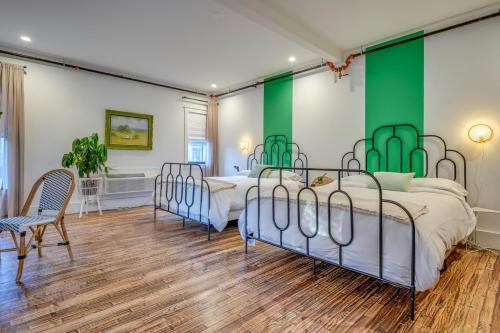 two beds in a room with green and white walls at Adina in Austin