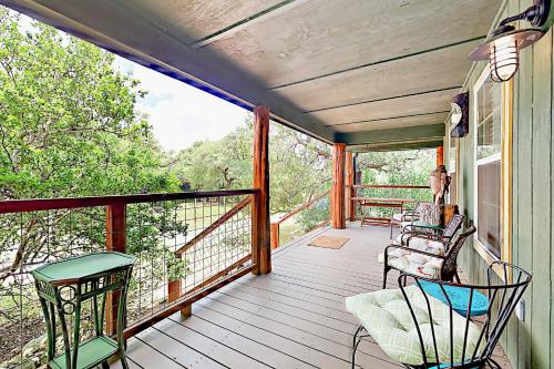 un porche con 2 sillas y una mesa en Cabin-Style Book House & Writing Barn en Austin