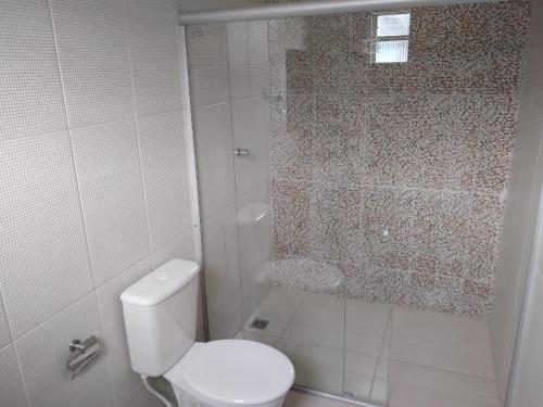 a white bathroom with a toilet and a shower at Pousada Portal da Villa in Vitória da Conquista