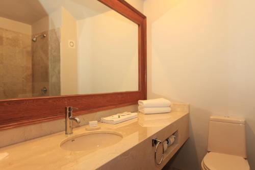 a bathroom with a sink and a mirror and a toilet at Real de Chapala in Ajijic