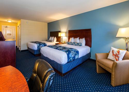 a hotel room with two beds and a chair at Bar Harbor Manor in Bar Harbor