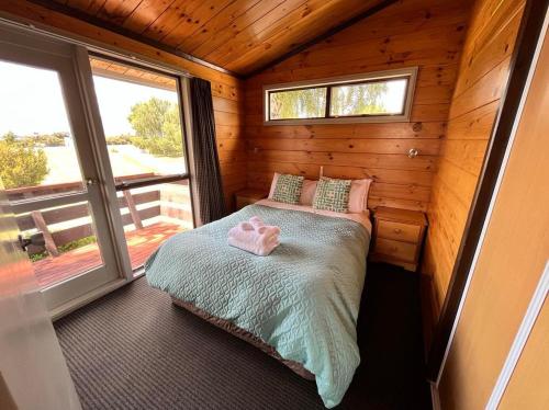 a small bedroom with a bed in a wooden cabin at Church House Beside the Lake in Lake Tekapo