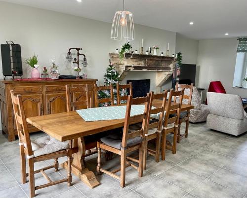 une salle à manger avec une table et des chaises en bois dans l'établissement Chez la Rose luxueuse cottage avec jacuzzi, à Rouvres-la-Chétive