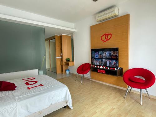 a bedroom with two red chairs and a bed at Private Jacuzzi Staycation at KL City 152 in Kuala Lumpur