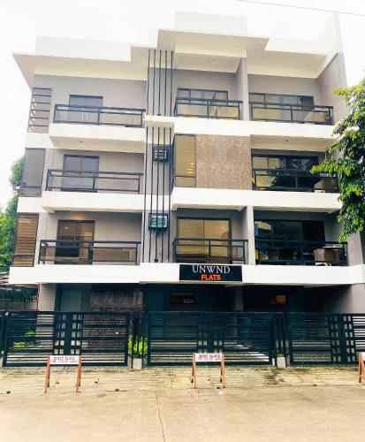 a white building with a sign in front of it at UNWND Residences Dumaguete in Dumaguete