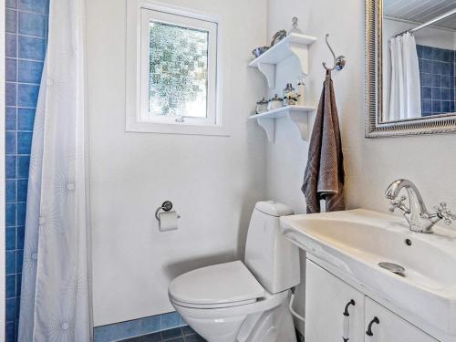 a white bathroom with a toilet and a sink at 6 person holiday home in Vinderup-By Traum in Vinderup