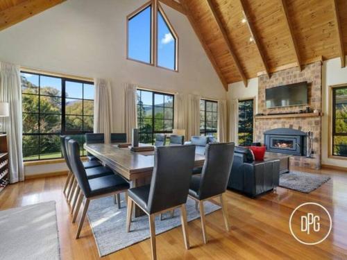 a dining room with a table and chairs and a fireplace at Himalayinn in Merrijig