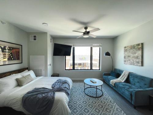 a bedroom with a bed and a couch at Sleepover Studio Apartments Des Moines in Des Moines