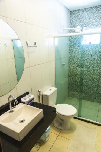 a bathroom with a sink and a toilet and a mirror at CASA TORRES in Bonito