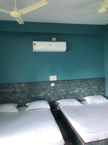 two beds in a room with a blue wall at SM MANSION near Harbour & High court in Chennai